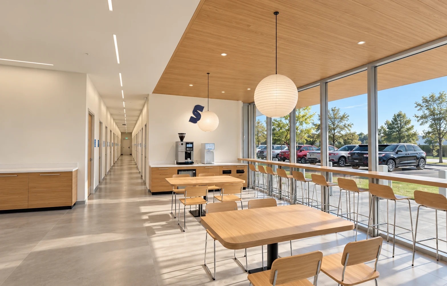Design rendering of the bright lobby with warm oak tables, window seating, paper lanterns, flush wood ceiling and coffee counter